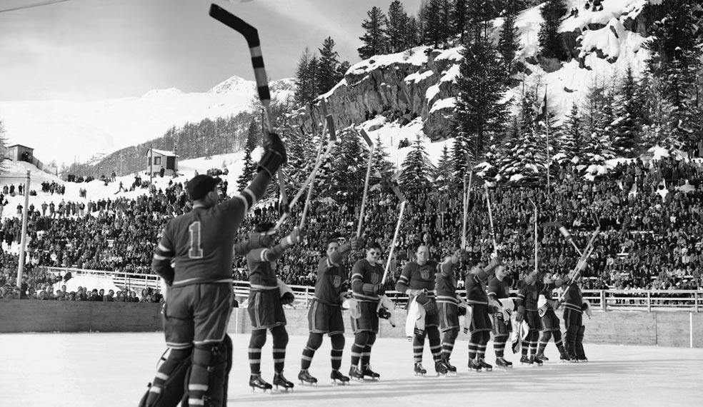 An ice hockey team celebrate victory at an early Winter Olympics